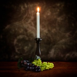 Vintage Illumination: Antique Candlestick with Grapes and Flame